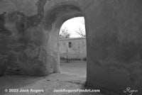 a black and white photo of an archway in an old building