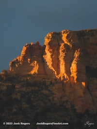 a rock formation with a cloudy sky in the background