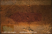 a brown piece of paper with a red mark on it